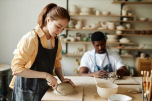 Woman and a man building pottery skills