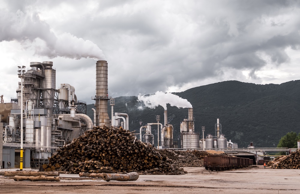 Industrial furniture plant with tree logs and air pollution