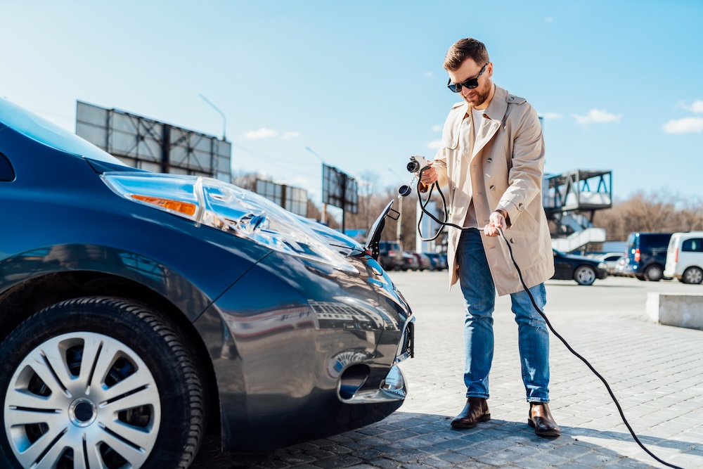 Man charging his electric economy car