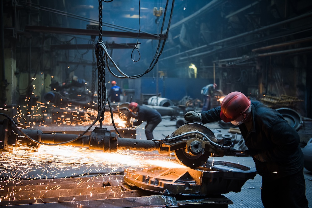 welder grinding stone on steal at a factory