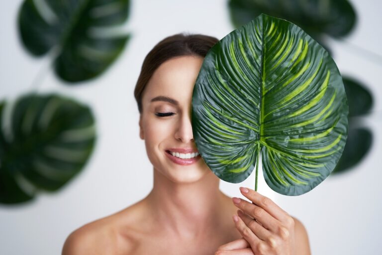 Woman smiling and posing with a leaf