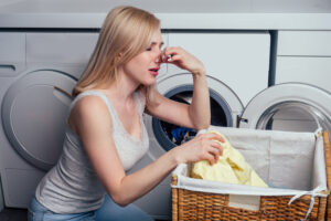 woman holding nose because of a bad smell on her clothes