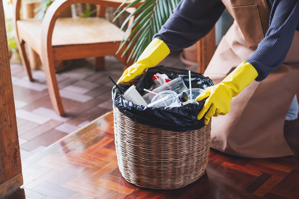woman taking out trash can full of garbage and recyclables