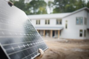 person carrying a solar panel to install on home