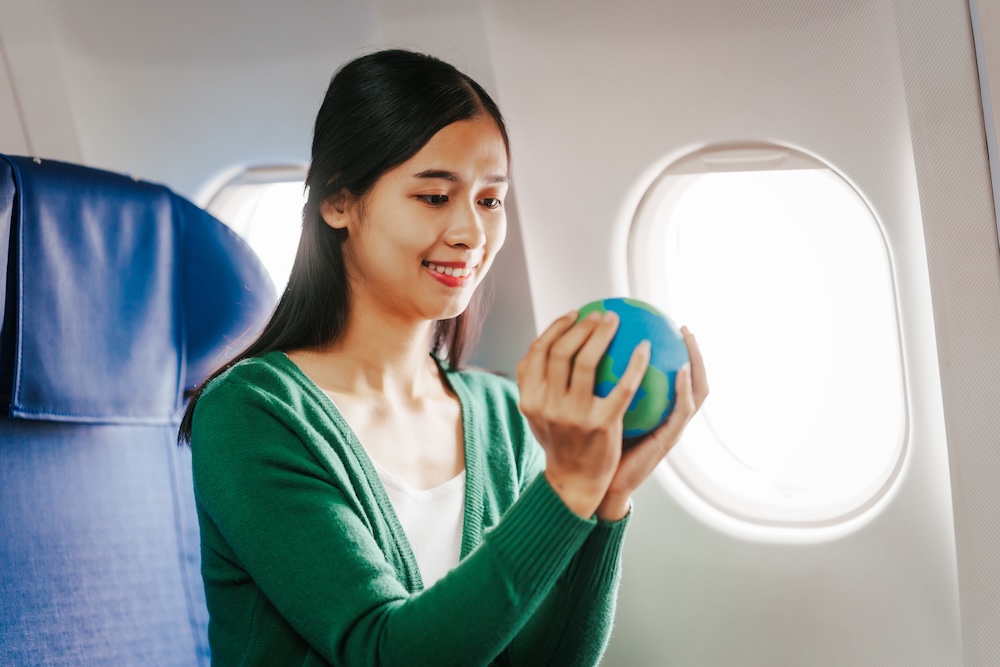 woman holding the earth between her hands on a flight