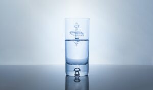 drop of water into a glass of ionized water creating a splash