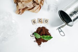words spelling eco with plastic paper and tin on a table