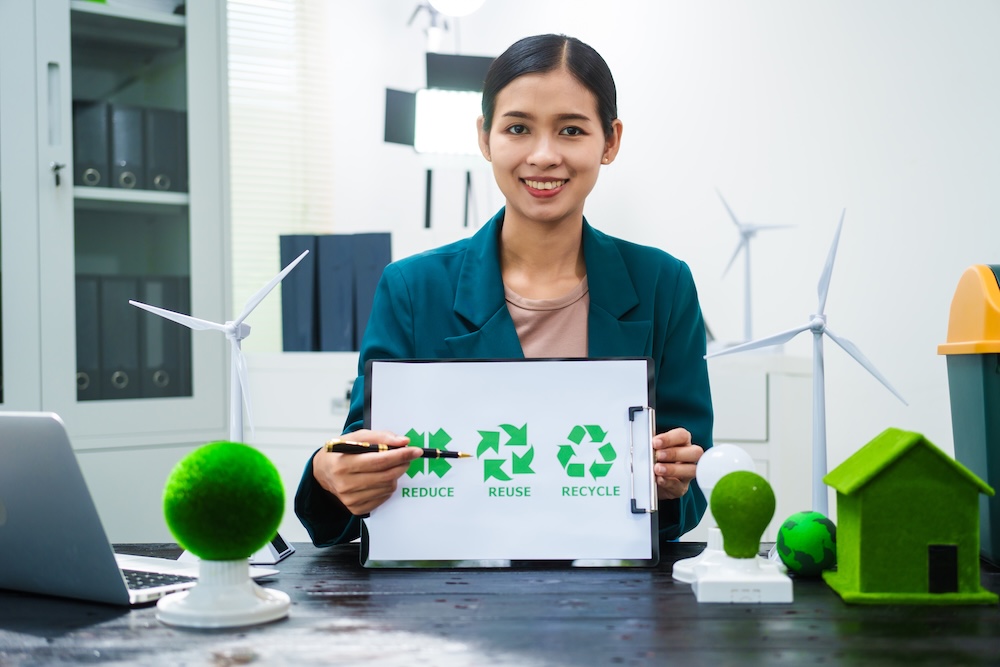 business woman holding a recycle sign in an office