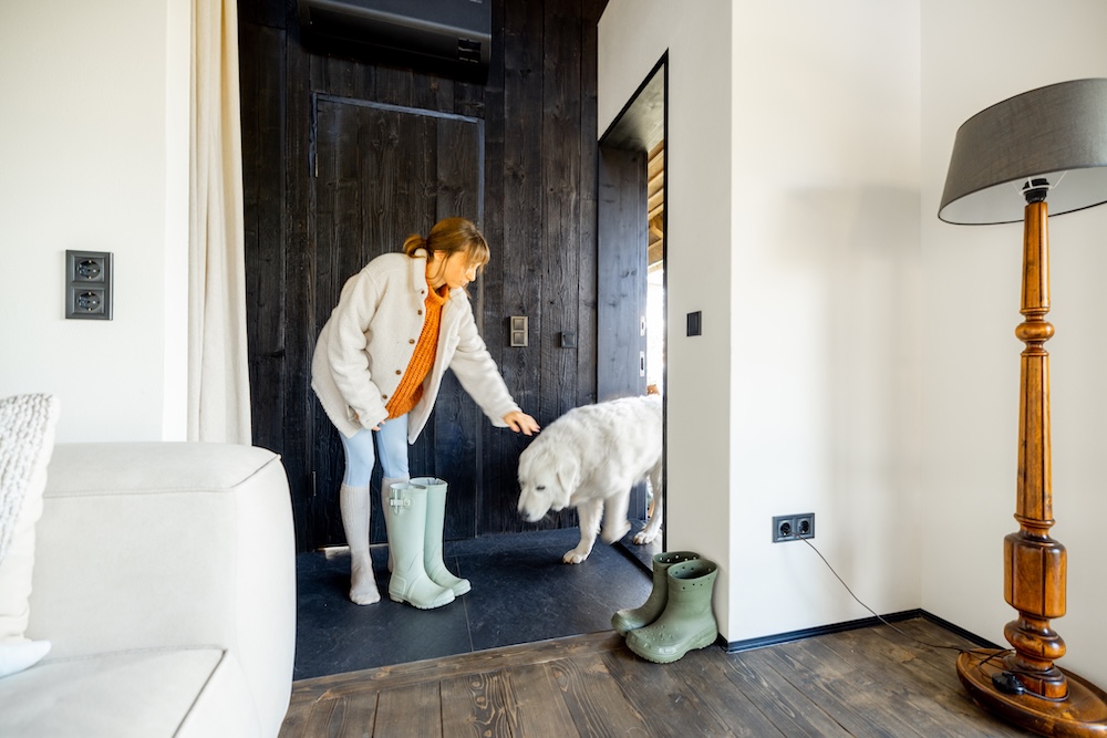 woman coming in through the entryway from walking her dog