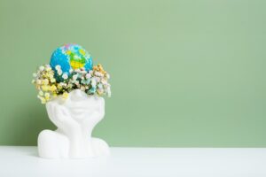 vase shaped like a head with earth on top