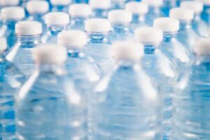 factor of plastic bottles filled with water creating microplastics
