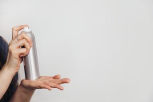 person holding an aerosol spray in their hand