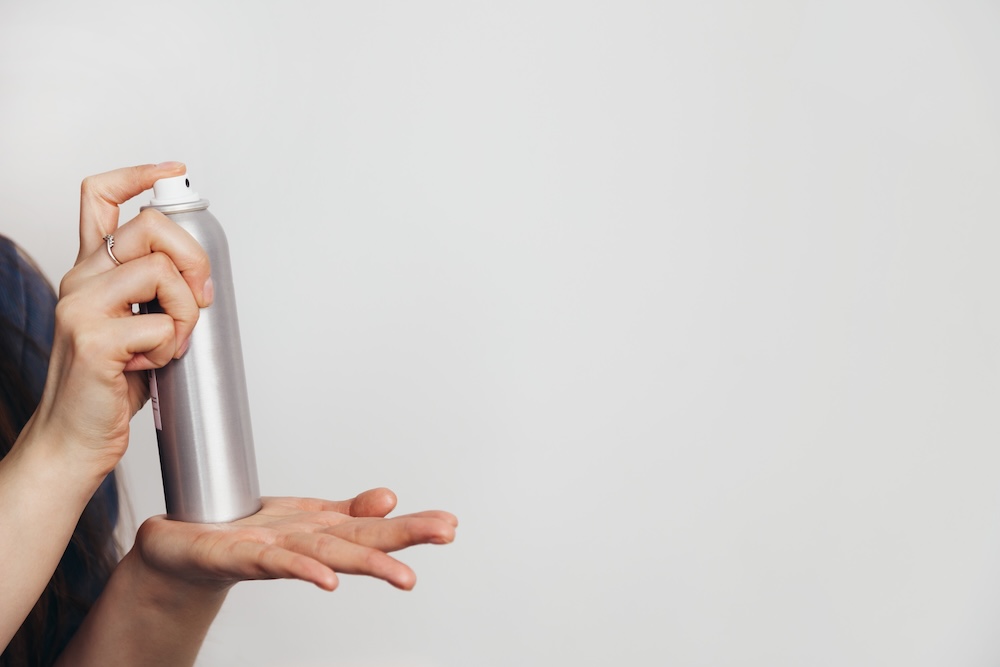 person holding an aerosol spray in their hand