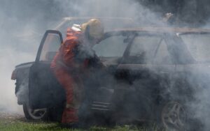 fire team in the middle of burning car polluting the air