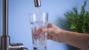 person filling up a glass with water