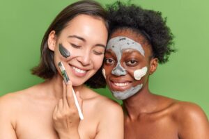 two women smiling wearing natural facial masks