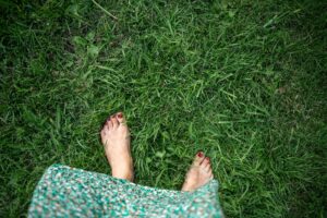 woman walking barefoot in the grass