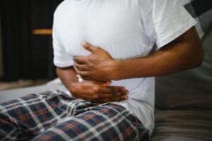 man holding stomach from bloating aches