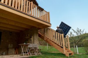 man carrying solar panel for off-grid home
