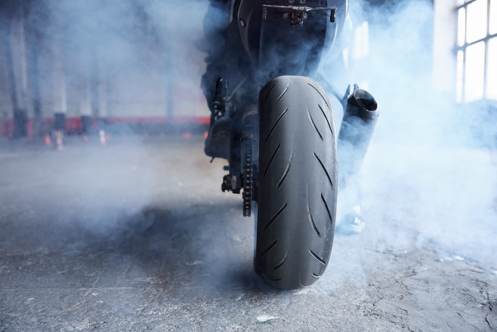 person on a motorcycle squeezing clutch causing pollution