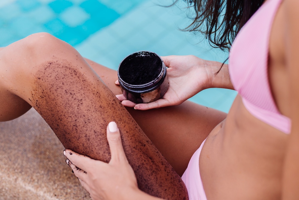 woman applying self tanner to her legs outdoors