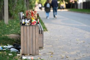 trashing falling out of trash can at a park