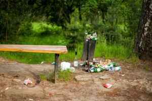 garbage overflowing a trash can in nature