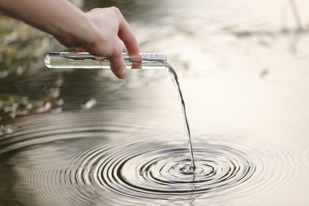 hand pouring water from tube