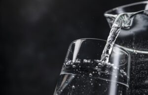 pouring water into a cup on a black background