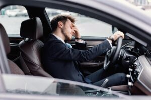 businessman tired from commuting to work sitting in his car
