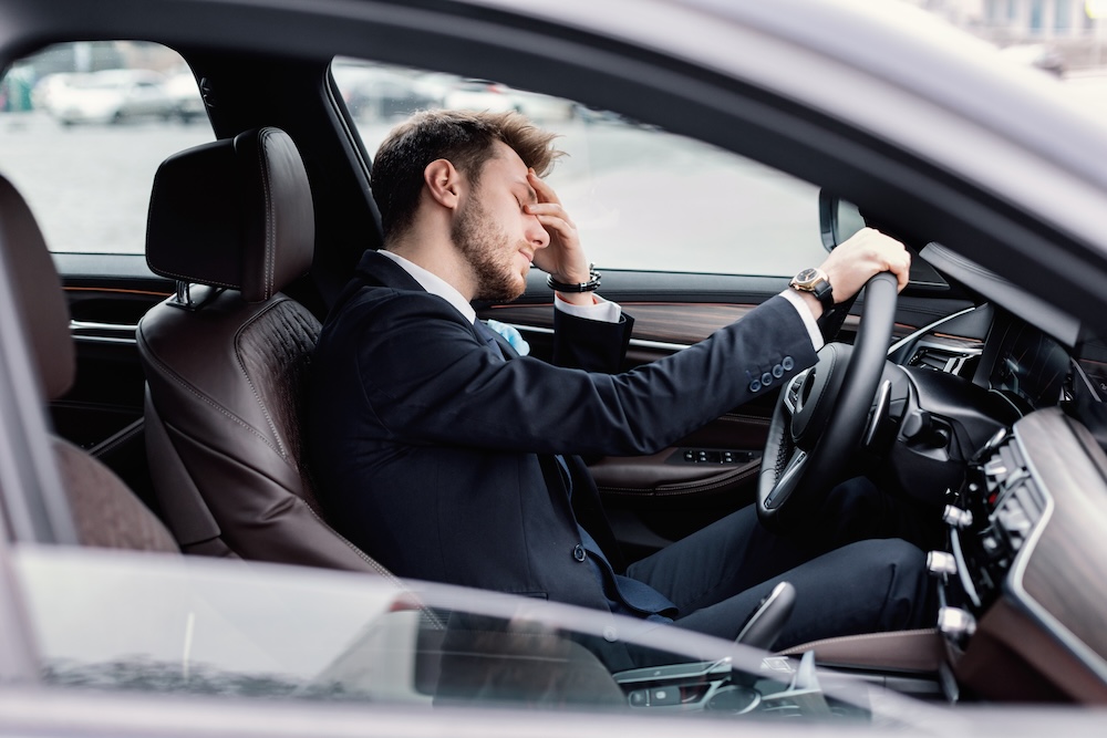 businessman tired from commuting to work sitting in his car