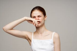 woman smelling stinky hands