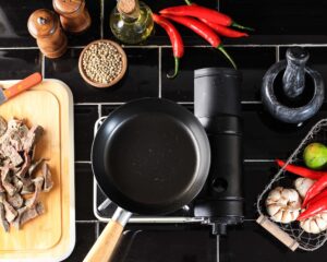 non-stick frying pan on stove with food around it