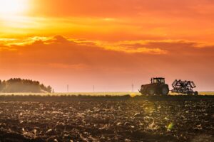 tractor in a field with sunrising in the background