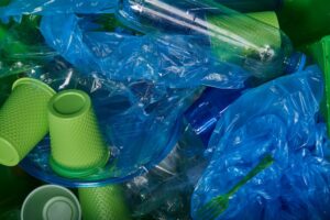 Green plastic cups and blue plastic bags mixed together