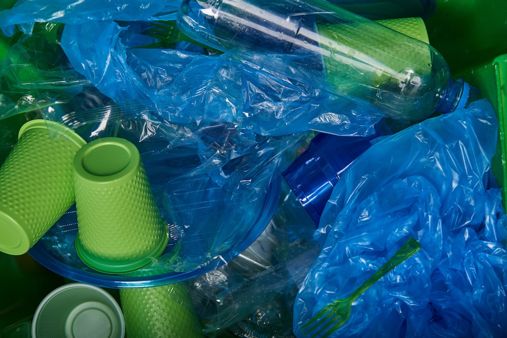 Green plastic cups and blue plastic bags mixed together