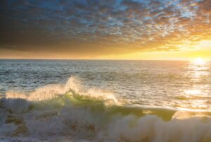 ocean waves crashing with the sun warming up the water