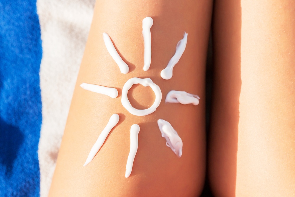 sun screen in shape of sun on woman's thigh
