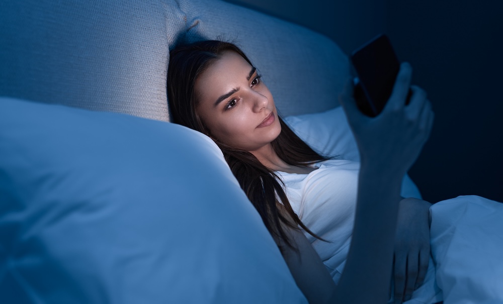 woman on her smartphone at night unable to sleep