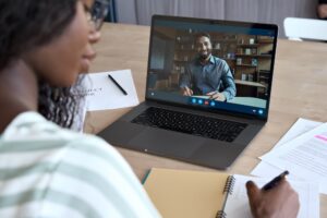 woman taking notes on a virtual call