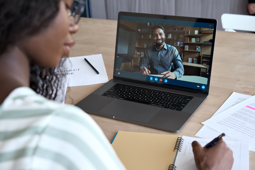 woman taking notes on a virtual call