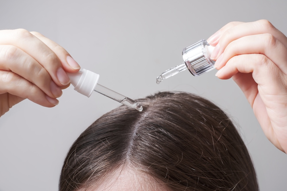 woman treating scalp with oil treatment