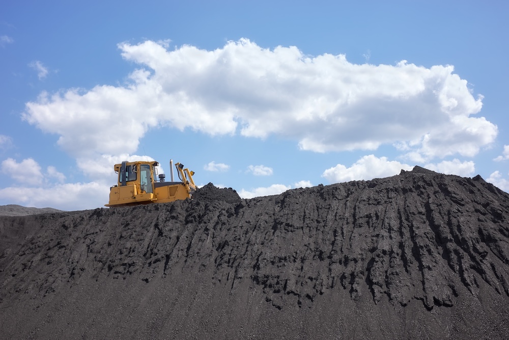 bulldozer on a coal hill with a blue sky