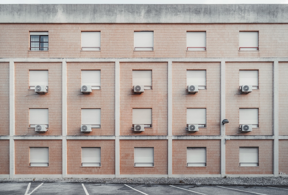 building with many hvac systems sitting outside windows