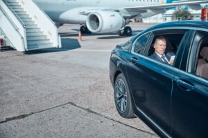 Rich white man driving away from his private jet