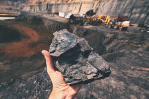 person holding piece of coal at a coal mine