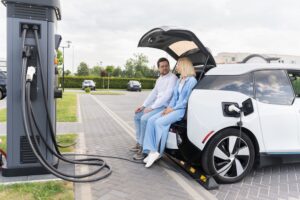 couple sitting in trunk while charging EV vehicle