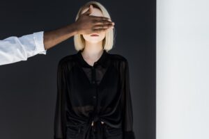 Person holding a black hand over a white blond face