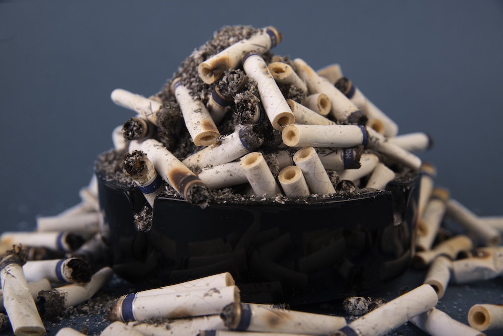 mount of cigarettes overflowing an ashtray