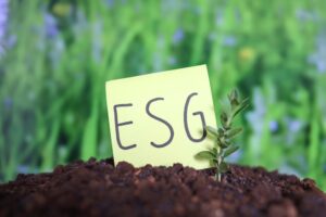 ESG on a post-it note in soil with grass in background